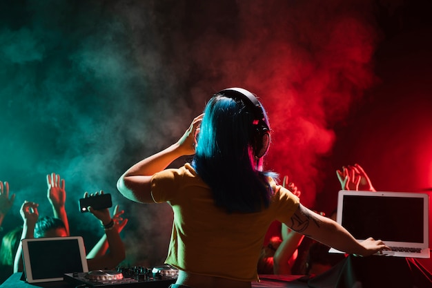 Foto dj femenino en la mesa de mezclas en el club