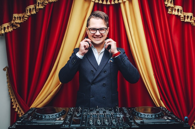 Dj joven guapo con auriculares guiñando un ojo y sonriendo