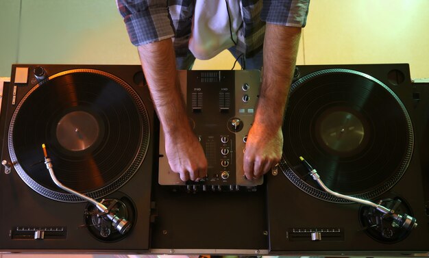 Dj masculino tocando música en el club, vista superior