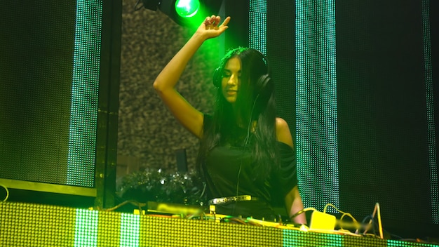 DJ no palco em boate discoteca misturando o ritmo da música techno