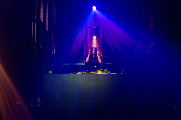 DJ no palco em boate discoteca misturando o ritmo da música techno
