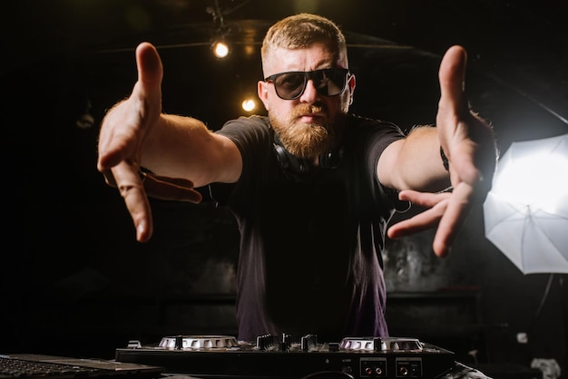 DJ toca en un mezclador en el club sobre fondo negro