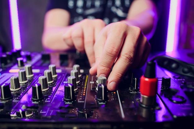 DJ tocando close up de mixer de música