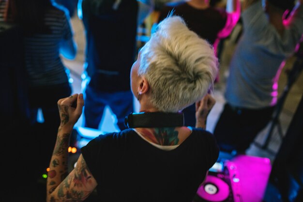 DJ tocando música no mixer de som em boate