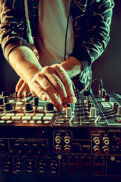 DJ tocando música en primer plano mezclador