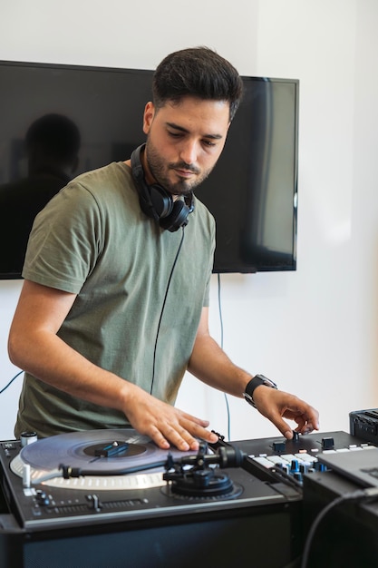 DJ tocando el tocadiscos mientras suena la música en su estudio