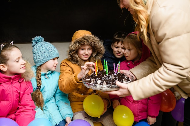 Dnipro Ucrania 21 de marzo de 2022 Fiesta de cumpleaños infantil en un refugio antiaéreo durante un ataque aéreo Los niños prueban el pastel de cumpleaños