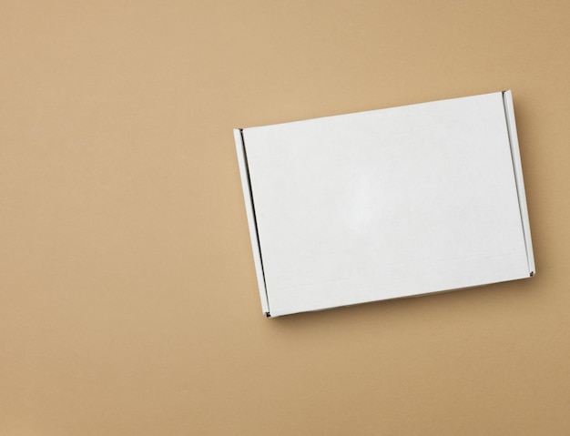 Foto dnn_8585 caixa retangular de papel branco em fundo bege vista superior