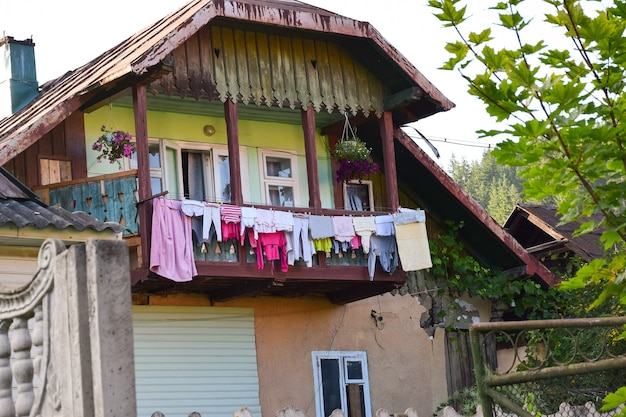 Do lado de fora de uma velha casa de campo privada, várias roupas de cama lavadas e limpas estão penduradas em cordas