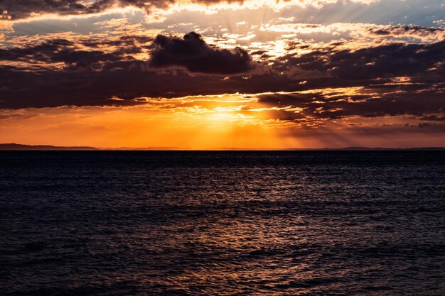 Foto por do sol quente em meio ao mar