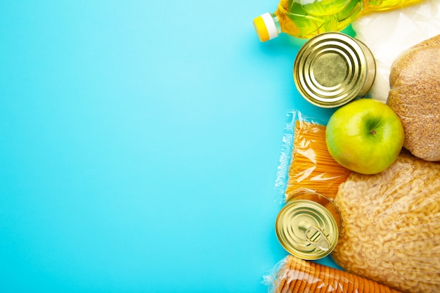 Doações de alimentos para pessoas. Comida de doação sobre o fundo azul. Vista do topo.