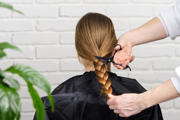 Doações de cabelo de mulher para pessoas com câncer conceito de doação de cabelo cortando cabelos longos trançados