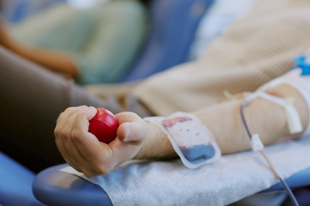 Doar sangue com a bola vermelha de estresse na mão
