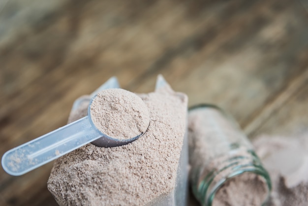 Foto doble chocolate proteína de suero de leche en polvo cuchara nutrición saludable comida culturismo.