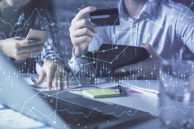 Doble exposición de compras en línea de hombre y mujer con una tarjeta de crédito y dibujo de holograma gráfico de forex Mercado de valores Concepto de pago en línea de comercio electrónico