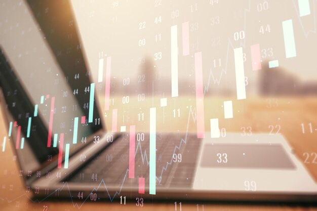 Doble exposición de diagramas financieros creativos abstractos en el concepto de banca y contabilidad de fondo de la computadora portátil moderna