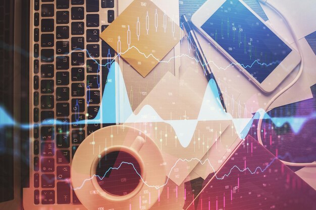 Doble exposición del dibujo del gráfico financiero sobre el fondo de la tabla con computadora Concepto de investigación y análisis Vista superior