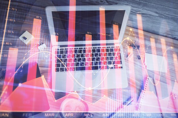 Doble exposición del dibujo del gráfico financiero sobre el fondo de la tabla con computadora Concepto de investigación y análisis Vista superior