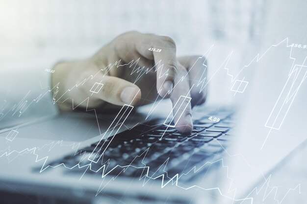 Doble exposición de un gráfico financiero creativo abstracto con escritura manual en el teclado de la computadora sobre investigación de antecedentes y concepto de estrategia