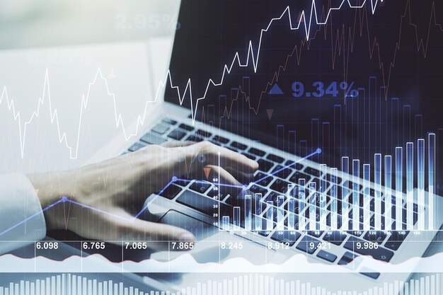 Doble exposición de gráfico financiero creativo abstracto con escritura manual en el teclado de la computadora sobre investigación de fondo y concepto de estrategia
