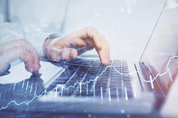 Doble exposición del gráfico de mercado con un hombre trabajando en una computadora en segundo plano Concepto de análisis financiero