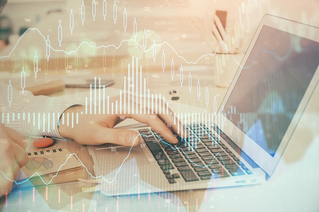 Doble exposición del gráfico del mercado de valores con un hombre trabajando en una computadora portátil en el fondo Concepto de análisis financiero