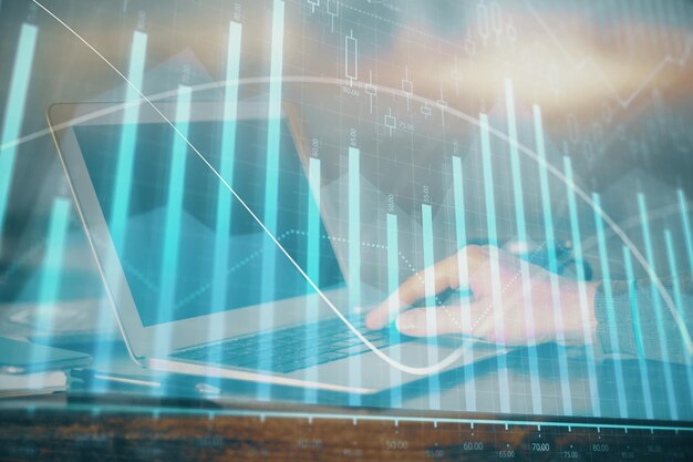 Doble exposición del gráfico del mercado de valores con un hombre trabajando en una computadora portátil en el fondo Concepto de análisis financiero