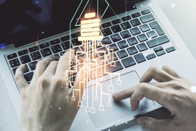Doble exposición del holograma de bombilla creativa con chip y manos escribiendo en una computadora portátil sobre una idea de fondo y un concepto de lluvia de ideas