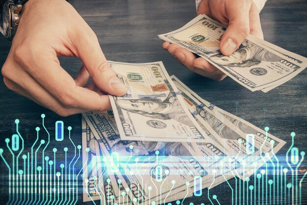 Doble exposición de holograma de dibujo de tecnología y billetes de dólares estadounidenses y manos de hombre Concepto de datos