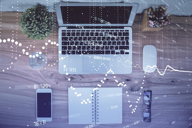 Doble exposición del holograma de dibujo del tema de datos sobre el fondo de la mesa de trabajo de la vista superior con la computadora Concepto de tecnología