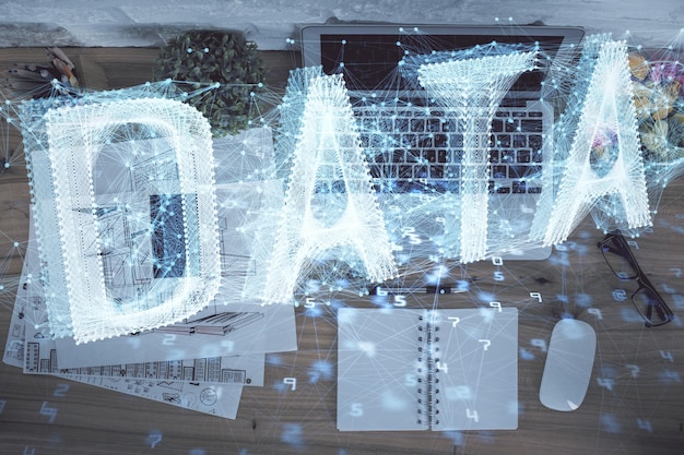 Doble exposición del holograma de dibujo del tema de datos sobre el fondo de la mesa de trabajo de vista superior con concepto de tecnología de computadora