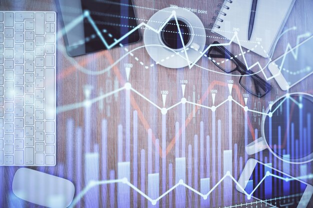 Doble exposición del holograma del gráfico financiero en el escritorio con el teléfono Vista superior Concepto de plataforma de comercio móvil