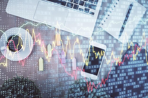 Doble exposición del holograma del gráfico financiero en el escritorio con el teléfono Vista superior Concepto de plataforma de comercio móvil
