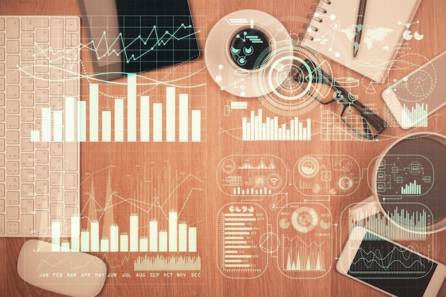 Doble exposición del holograma del gráfico financiero en el escritorio con el teléfono Vista superior Concepto de plataforma de comercio móvil