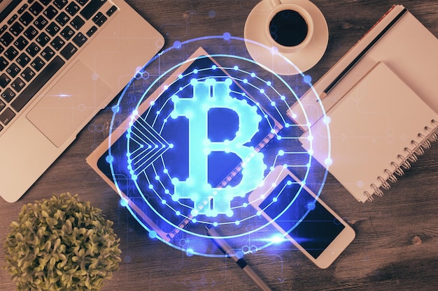 Doble exposición del holograma del tema blockchain sobre la mesa con el teléfono Vista superior Concepto de tecnología criptográfica