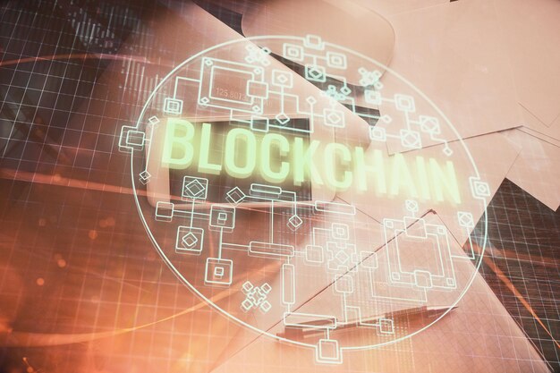 Doble exposición del holograma del tema blockchain sobre la mesa con el teléfono Vista superior Concepto de tecnología criptográfica