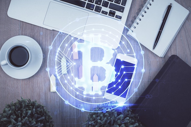 Doble exposición del holograma del tema blockchain sobre la mesa con el teléfono Vista superior Concepto de tecnología criptográfica