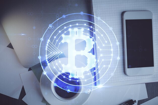 Doble exposición del holograma del tema blockchain sobre la mesa con el teléfono Vista superior Concepto de tecnología criptográfica