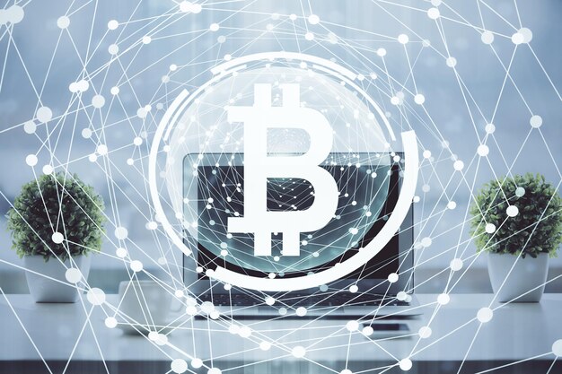 Doble exposición del holograma temático blockchain y criptoeconomía y mesa con fondo de computadora Concepto de criptomoneda bitcoin