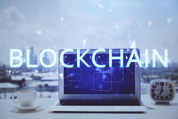 Doble exposición del holograma temático blockchain y criptoeconomía y mesa con fondo de computadora Concepto de criptomoneda bitcoin