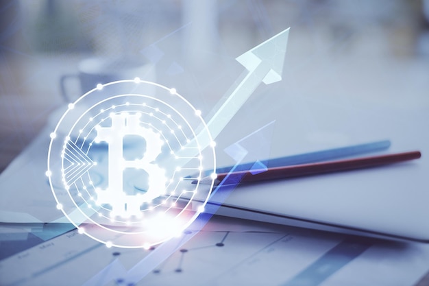 Doble exposición del holograma temático blockchain y criptoeconomía y mesa con fondo de computadora Concepto de criptomoneda bitcoin