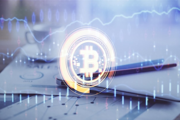 Doble exposición del holograma temático blockchain y criptoeconomía y mesa con fondo de computadora Concepto de criptomoneda bitcoin