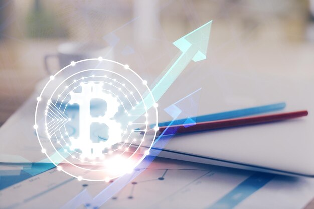 Doble exposición del holograma temático blockchain y criptoeconomía y mesa con fondo de computadora Concepto de criptomoneda bitcoin