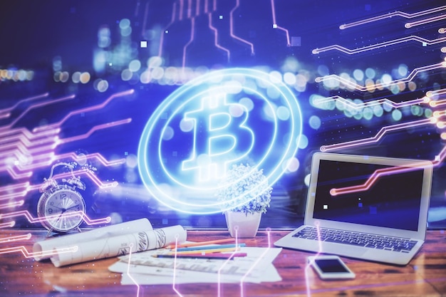 Doble exposición del holograma temático blockchain y criptoeconomía y mesa con fondo de computadora Concepto de criptomoneda bitcoin