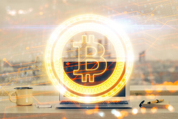 Doble exposición del holograma temático blockchain y criptoeconomía y mesa con fondo de computadora Concepto de criptomoneda bitcoin