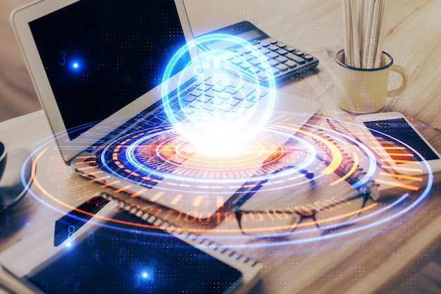 Doble exposición del holograma temático blockchain y criptoeconomía y mesa con fondo de computadora Concepto de criptomoneda bitcoin