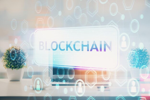 Doble exposición del holograma temático blockchain y criptoeconomía y mesa con fondo de computadora Concepto de criptomoneda bitcoin