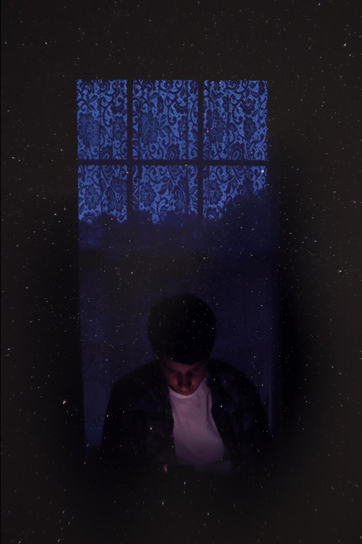 Foto doble exposición de un hombre en el cuarto oscuro y estrellas en el cielo por la noche