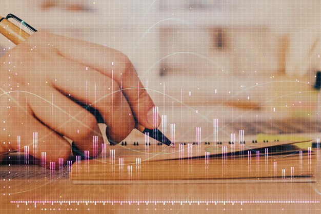 Doble exposición del hombre haciendo notas del mercado de valores con gráfico de forex Concepto de investigación y comercio