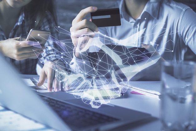 Doble exposición de un hombre y una mujer comprando en línea con una tarjeta de crédito y un dibujo de holograma de apretón de manos Concepto de asociación